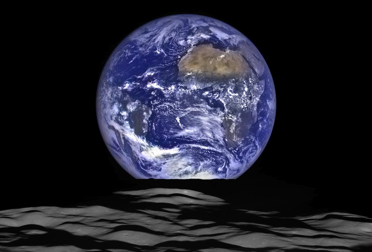 Planet Earth rising over black craters