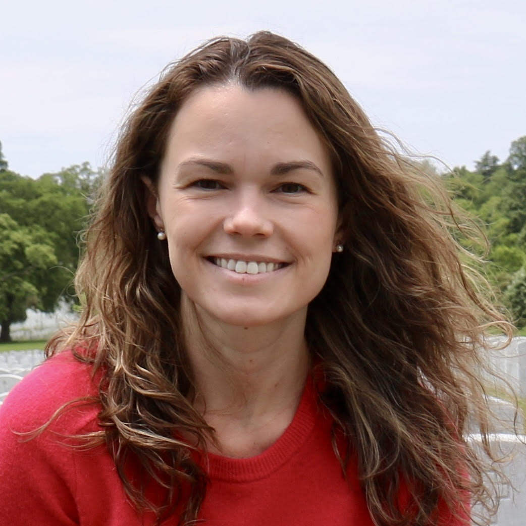 Head and shoulders picture of a young woman with brown hair, wearing a red shirt