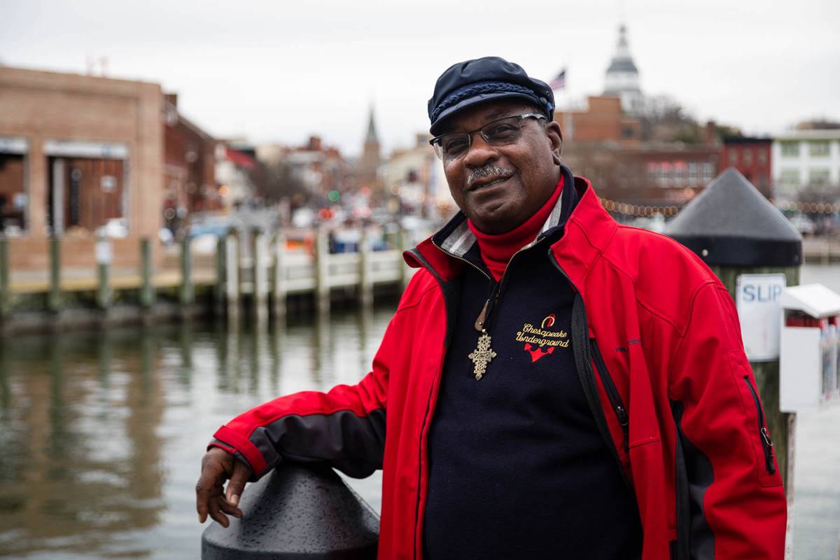 Vince Leggett in red jacket in front of docks