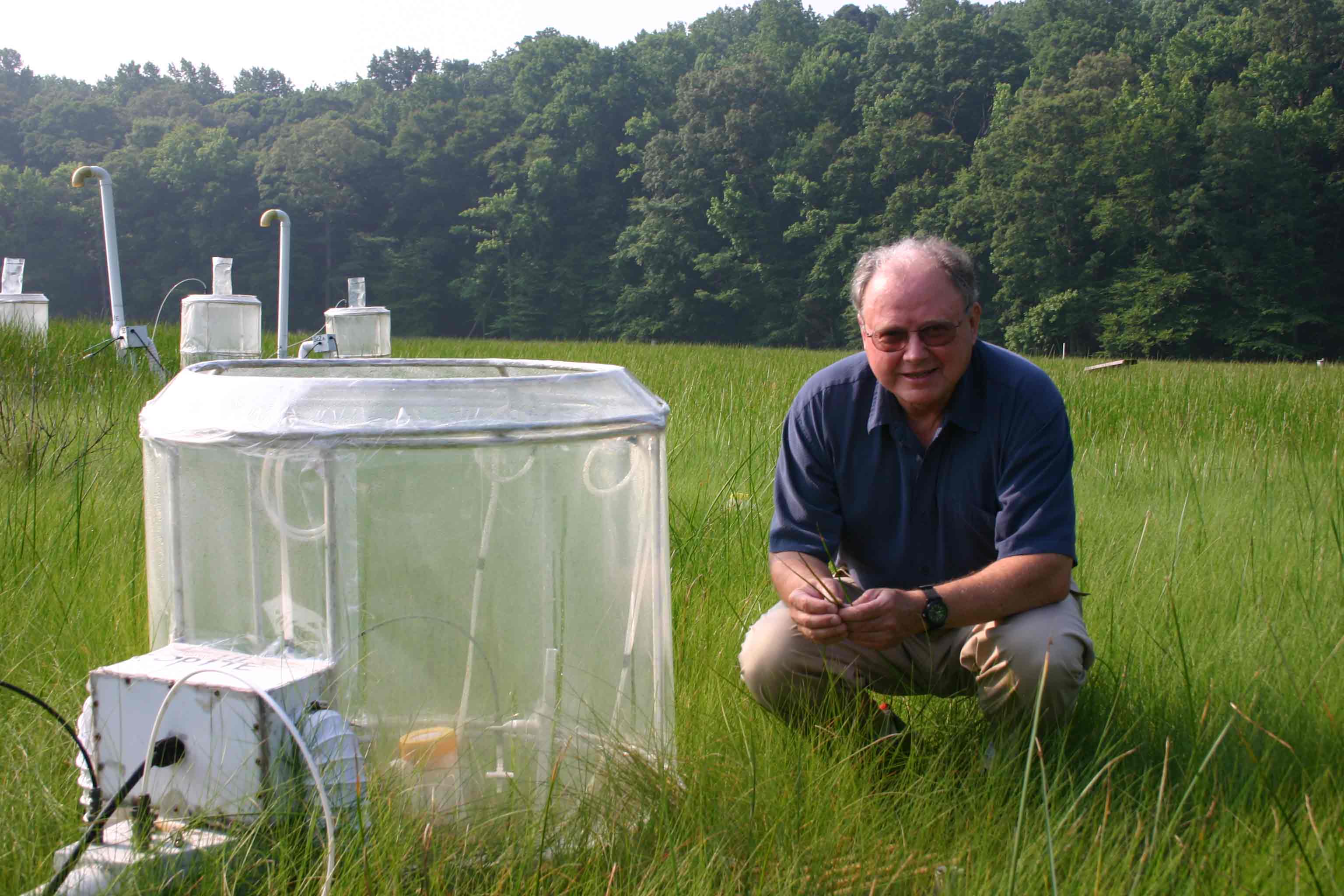 Bert Drake kneels beside CO2 chamber