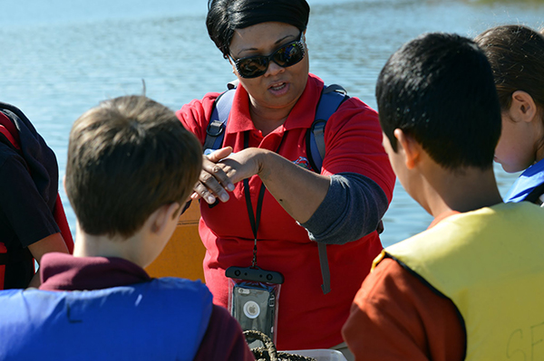 A SERC volunteer teaching a small group of students about oysters