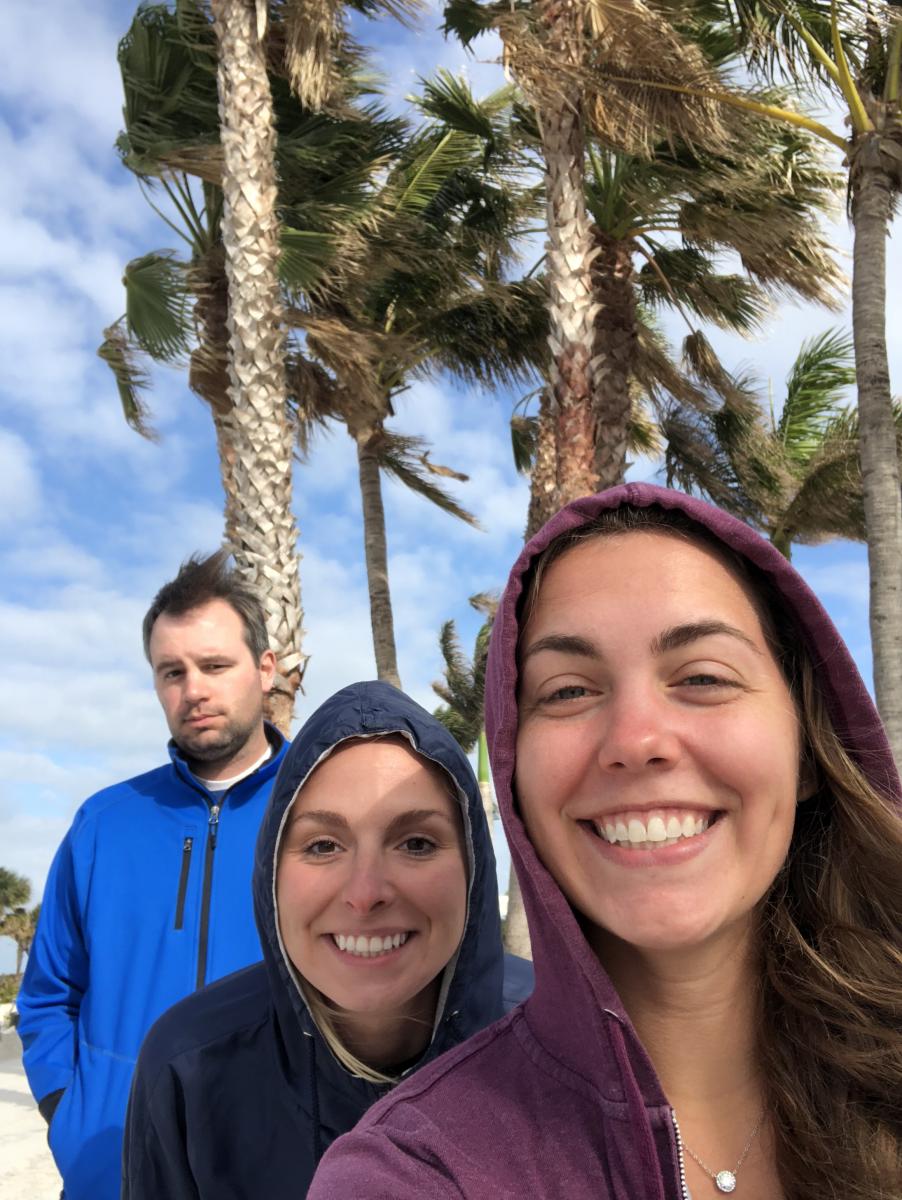 Selfie of three scientists in front of palm trees
