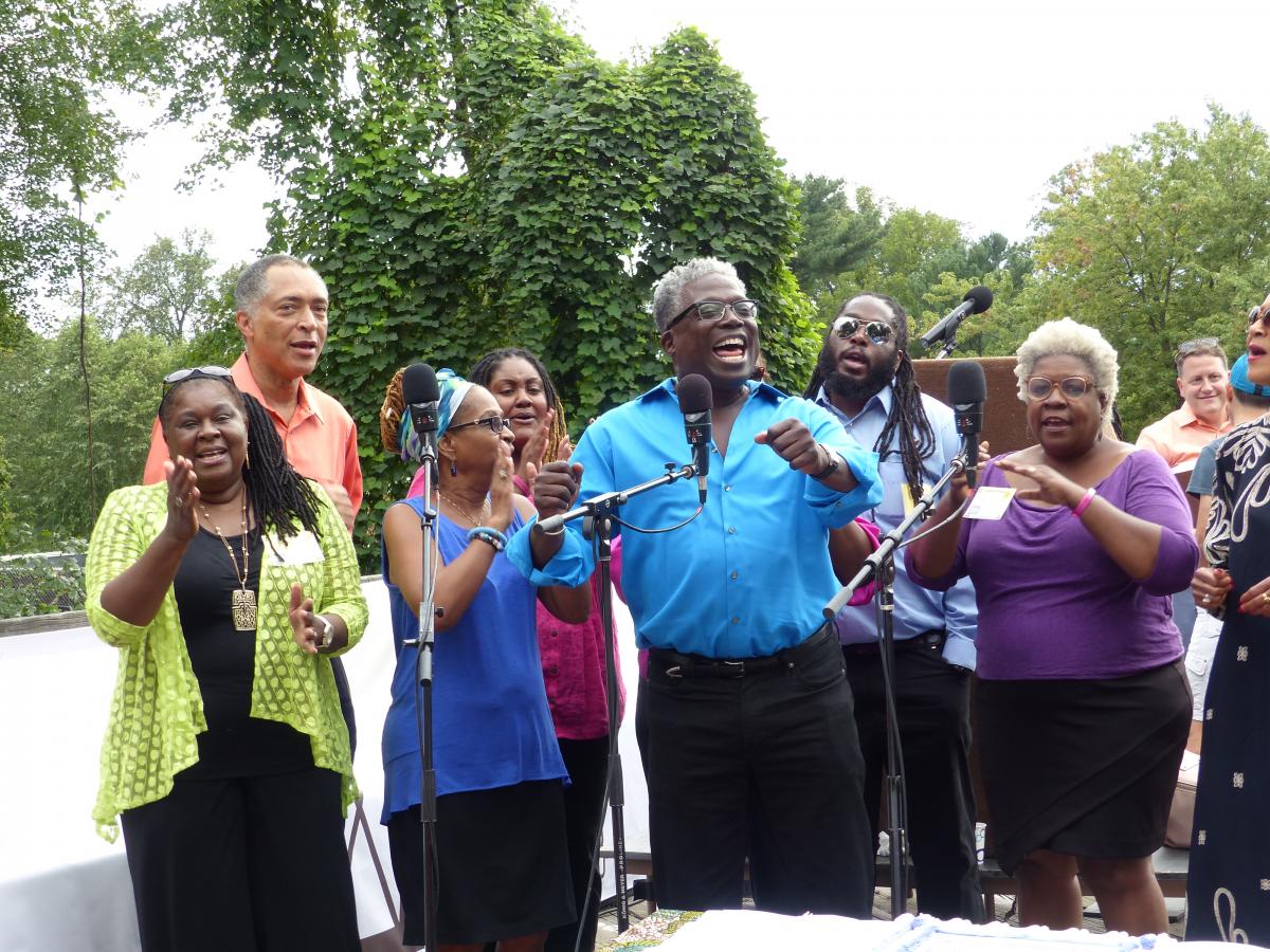 African-American choir singing beside a forest