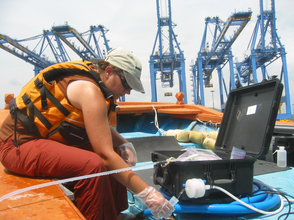 Monaca Noble collects a water sample near a port for analysis.