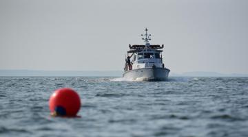 A SERC boat heading toward the camera under a gray sky