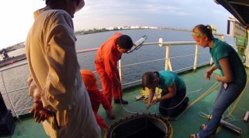 Drs. Jenny Carney and Katrina Lohan with crew members sampling ballast water