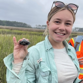 Victoria holding a diamondback terrapin turtle in a salt marsh