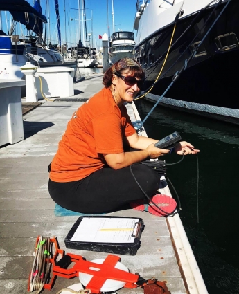 Scientist taking salinity measurements in a marina